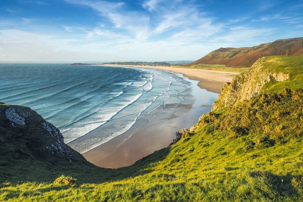 Scenic view of coastal cliffs and ocean waves under a clear sky, perfect for nature and travel themes.