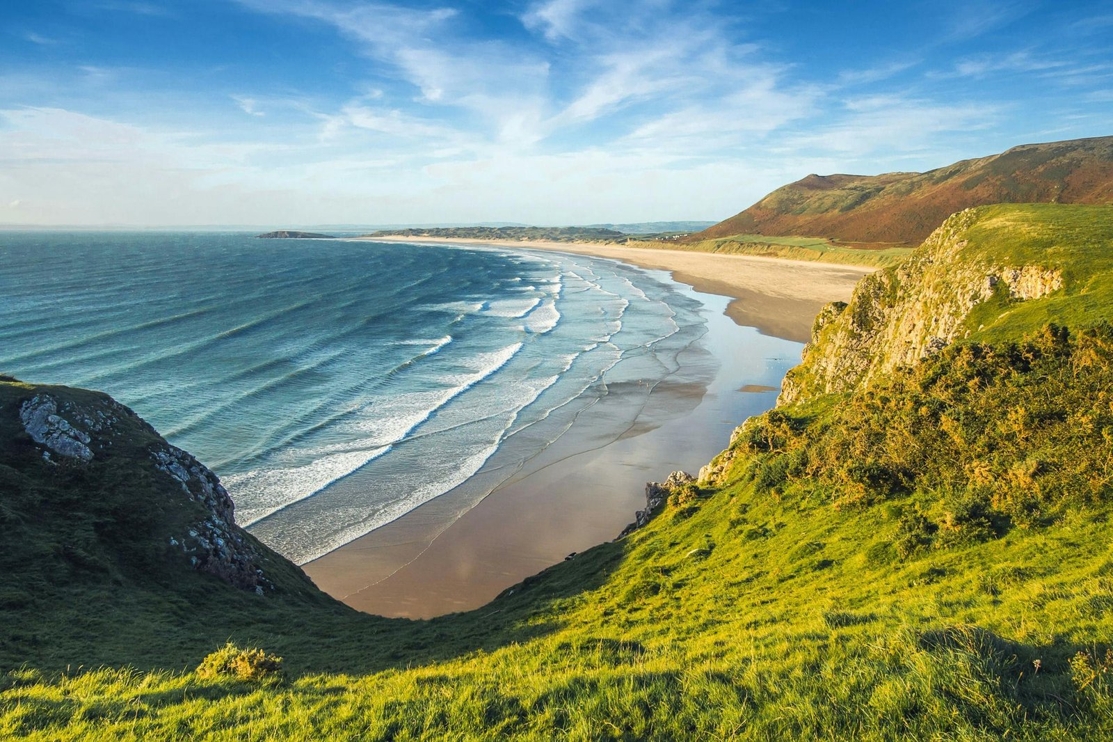 Scenic view of coastal cliffs and ocean waves under a clear sky, perfect for nature and travel themes.